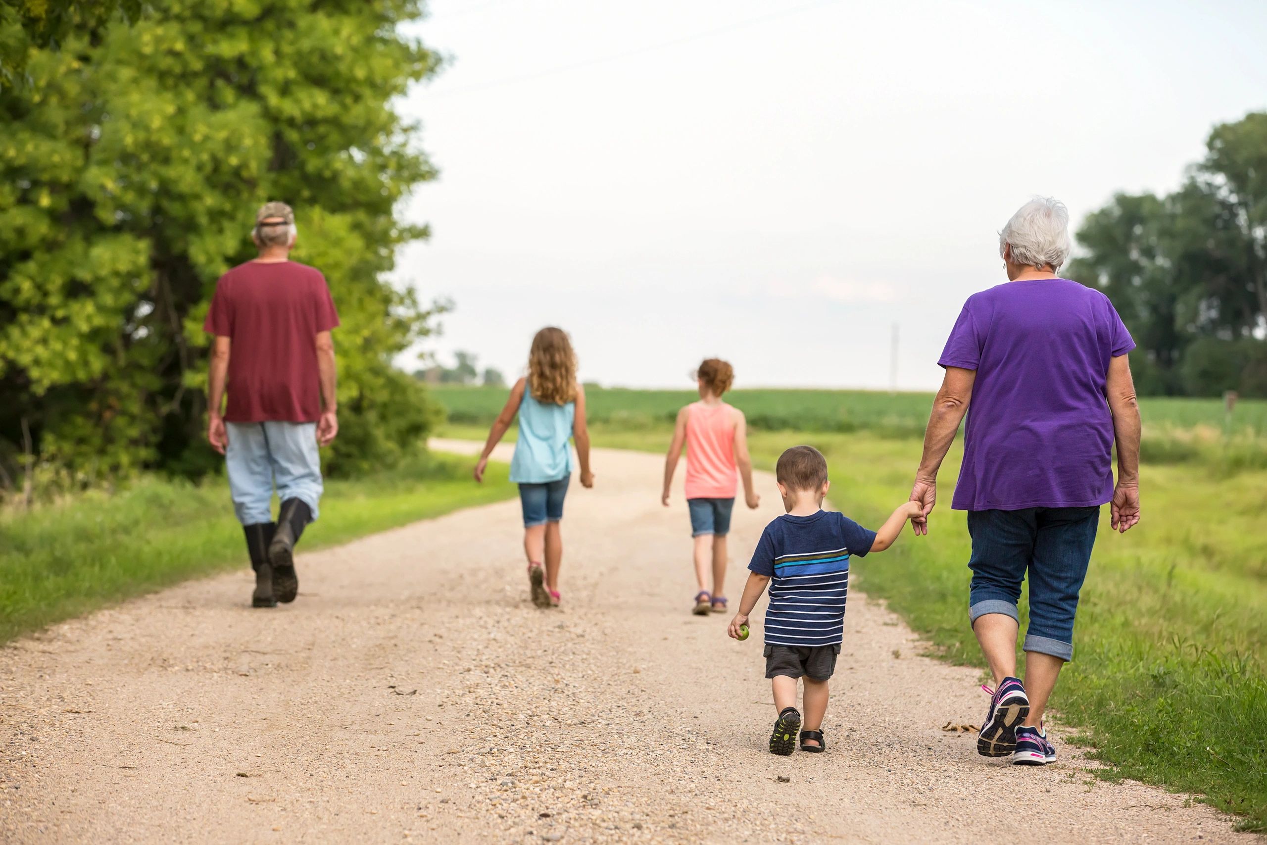 Family walking along a rural farm path