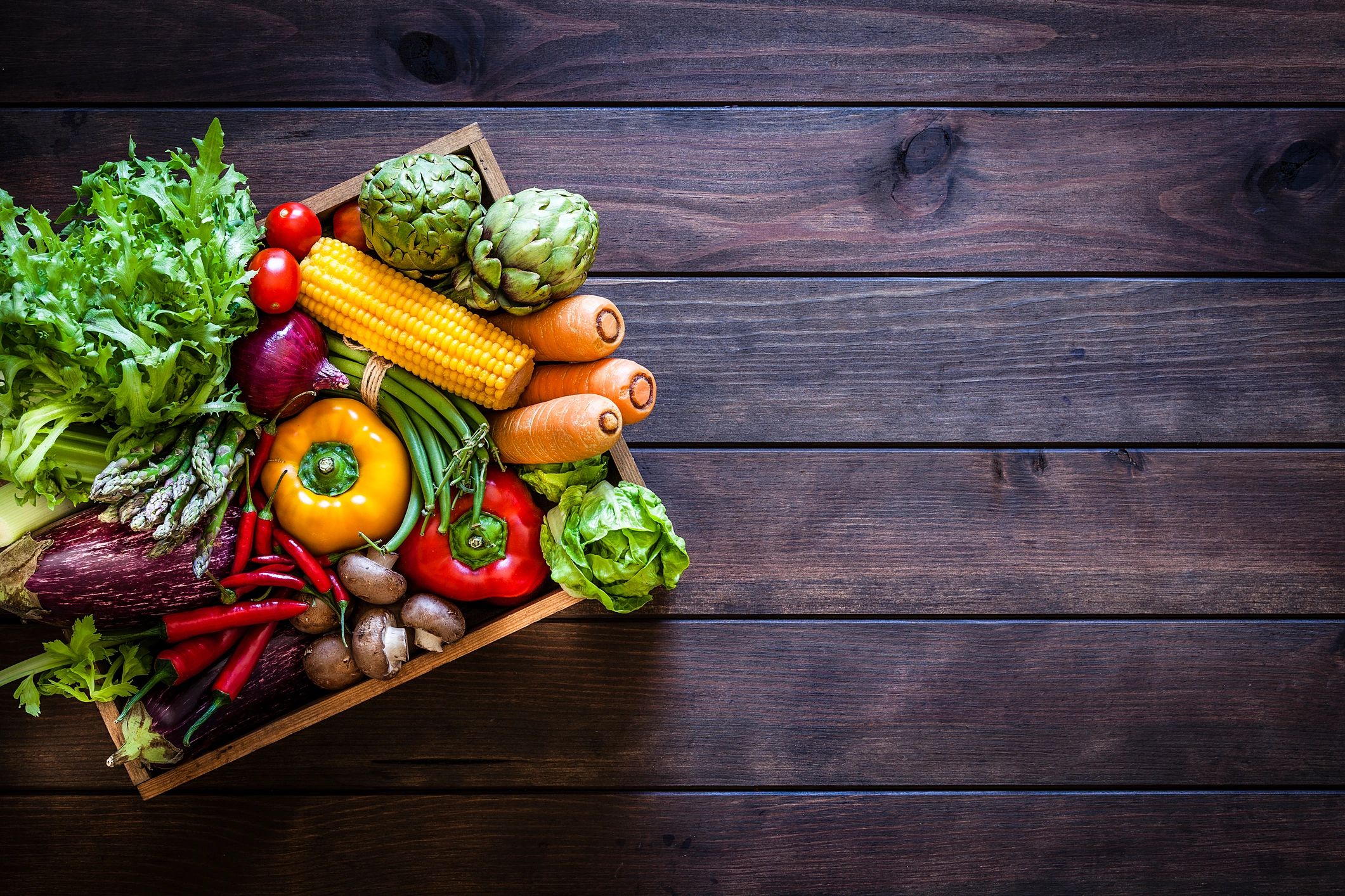 Top view of fresh organic vegetables in a wooden crate